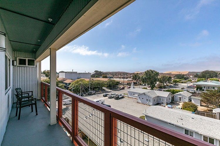 a balcony with a table and chairs and a view of a town