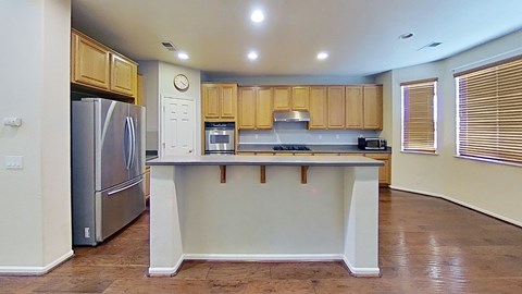A kitchen with wooden cabinets and a white island.