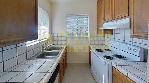 A kitchen with a white stove top oven and a white dishwasher.