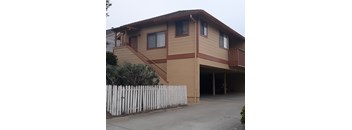 A two-story house with a white picket fence in front.