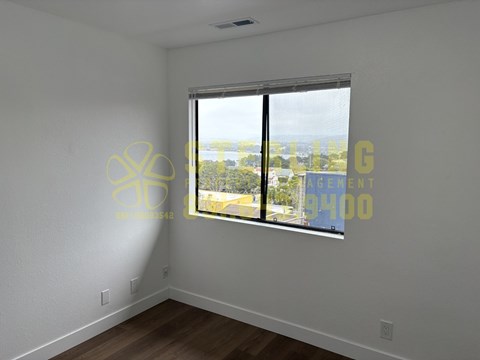 A room with a window showing a view of a cityscape.