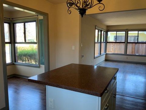 A kitchen with a brown counter top and white cabinets.
