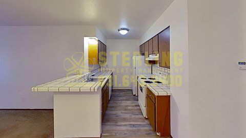 A kitchen with a white counter and a brown cabinet.