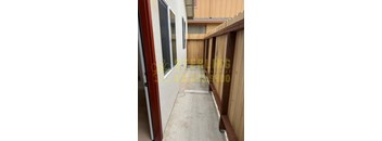 A view of a balcony with a red door and wooden fence.