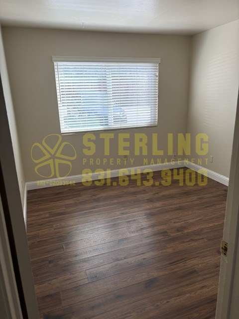 A Sterling Property Management logo is on the wall above a wood floor.