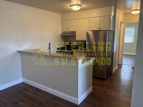 A kitchen with a stove top oven and a refrigerator.