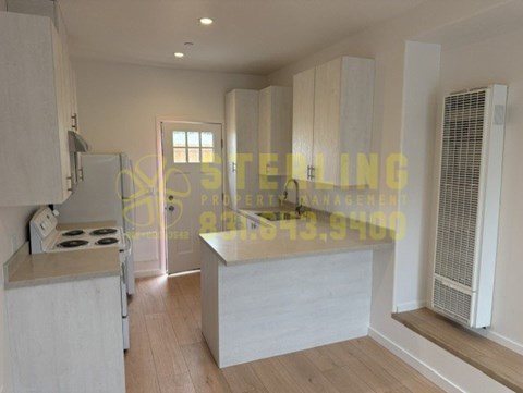 A kitchen with a stove, cabinets, and a countertop.