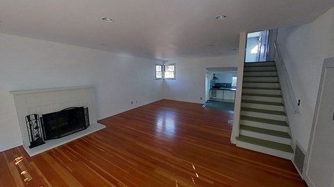 a living room with a fireplace and a wooden floor