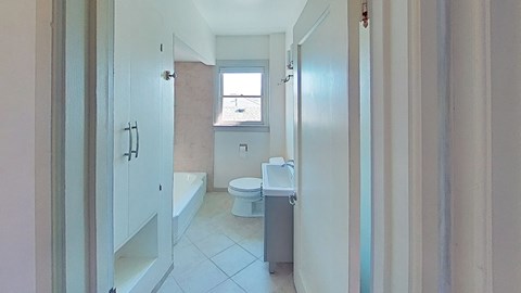a white bathroom with a toilet and a sink