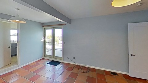 an empty living room with blue walls and orange tile floors