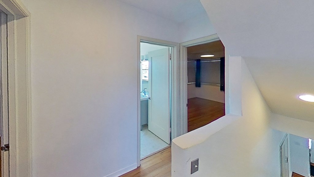 a living room with a staircase and a mirror in a house