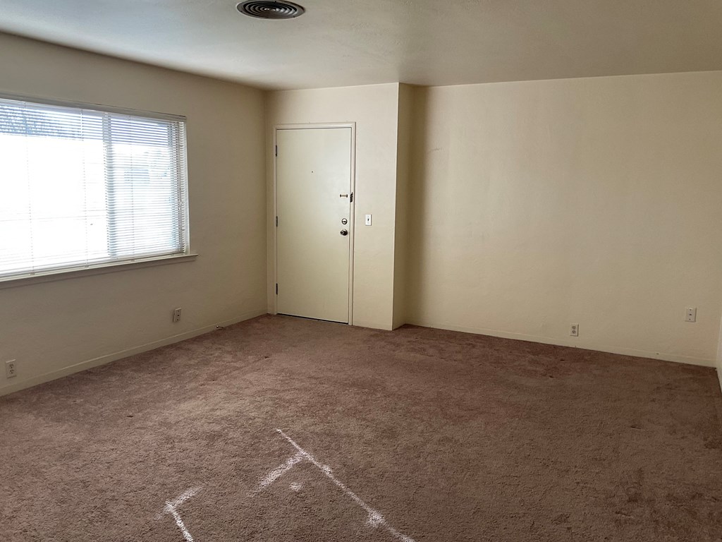 an empty room with a door and a window