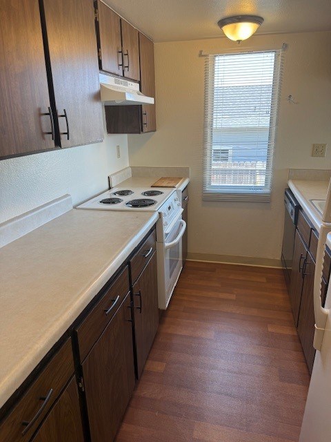 A kitchen with wooden cabinets and a white counter top.