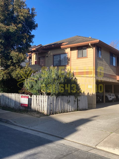 A house with a fence and a sign in front of it.