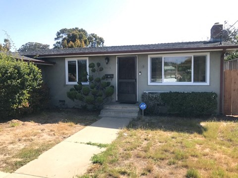 A house with a brown door and a window with a view of trees.