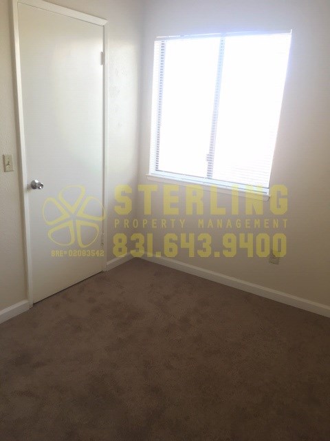 A Sterling Property Management logo is projected on a wall in an empty room.