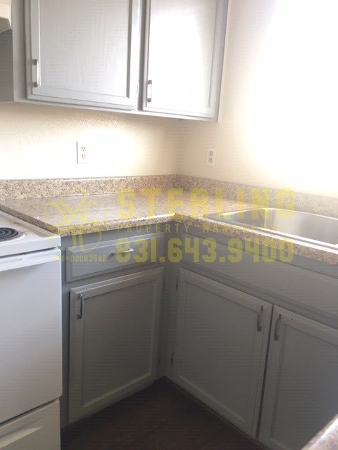 A kitchen with a white dishwasher and cabinets.