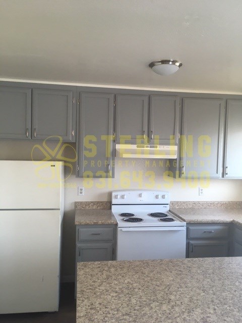 A kitchen with a white stove top oven and a white dishwasher.