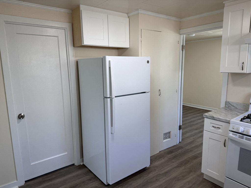 a kitchen with white cabinets and a white refrigerator