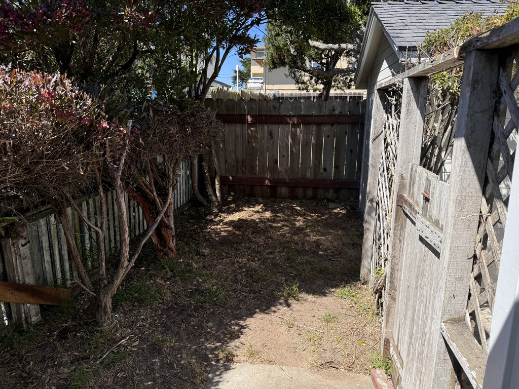 the backyard of a house with a fence and a gate