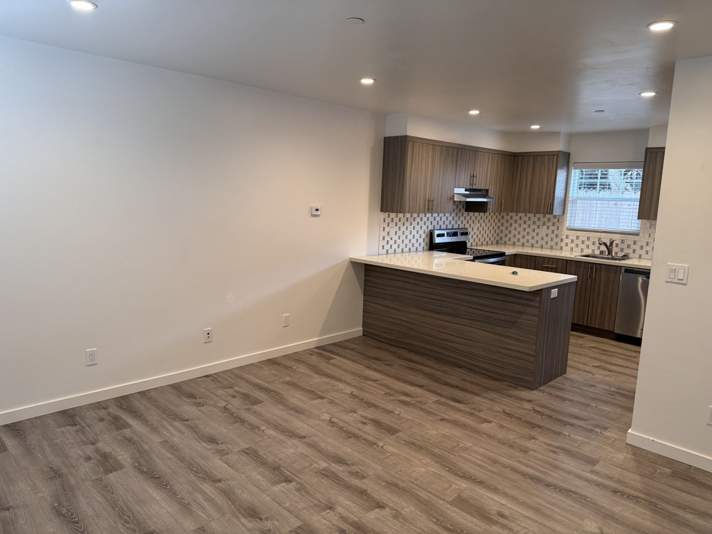 A kitchen with a wooden island and a stainless steel dishwasher.