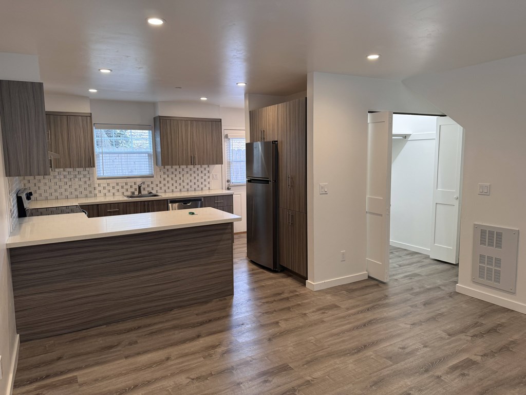 A kitchen with a white counter top and wooden cabinets.