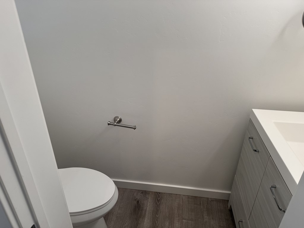 A white toilet sits in a small bathroom next to a sink.