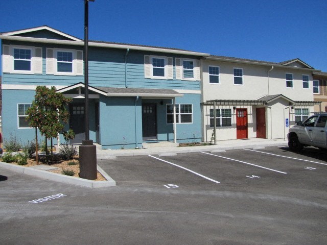 a blue building with a red door and a parking lot