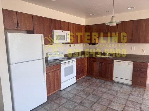 A kitchen with a refrigerator, stove, and dishwasher.
