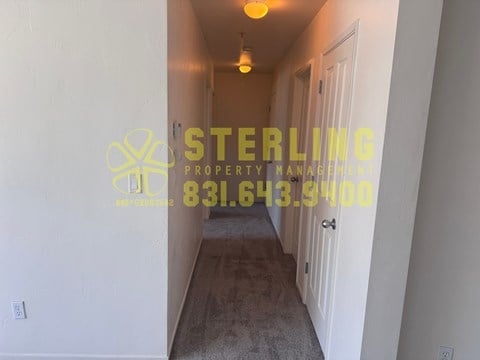 A hallway with a Sterling Property Management logo and phone number on the wall.