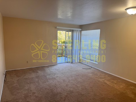 A room with a carpeted floor and a wall with a logo and text on it.