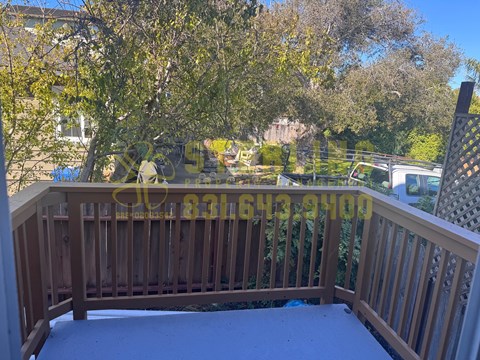 A wooden deck with a railing and a view of a backyard.