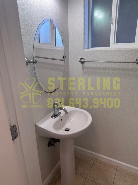 A white sink in a bathroom with a mirror above it.