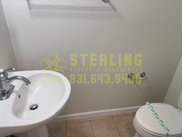 A bathroom with a toilet, sink, and a yellow text overlay.