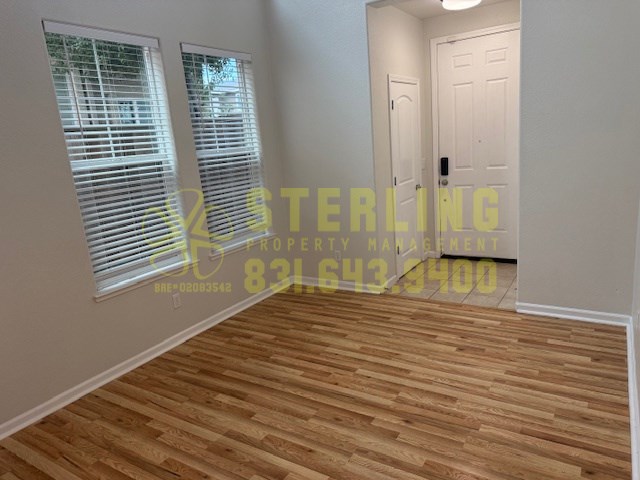 A room with wooden flooring and a door is shown.