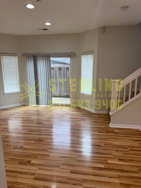 A room with wooden flooring and a staircase.