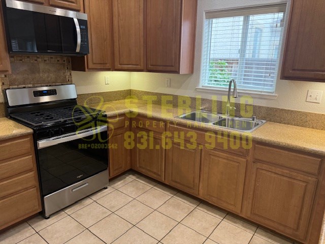 A kitchen with wooden cabinets and a stove top oven.