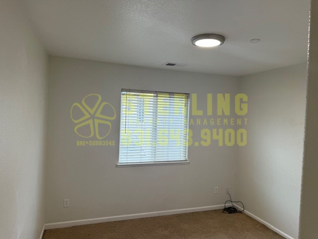 A room with a window and a logo on the wall.