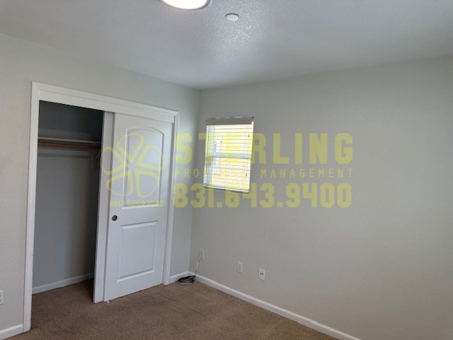 A room with a door and a window with blinds.