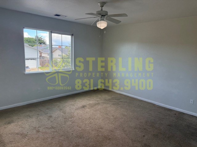 A room with a Sterling Property Management logo and contact number on the wall.