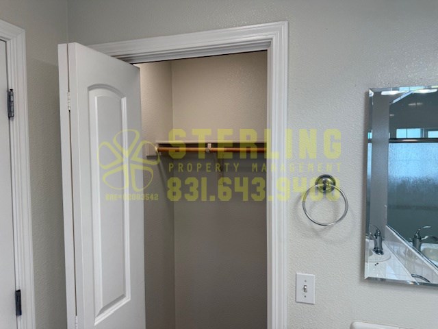 A bathroom with a white door and a mirror on the wall.