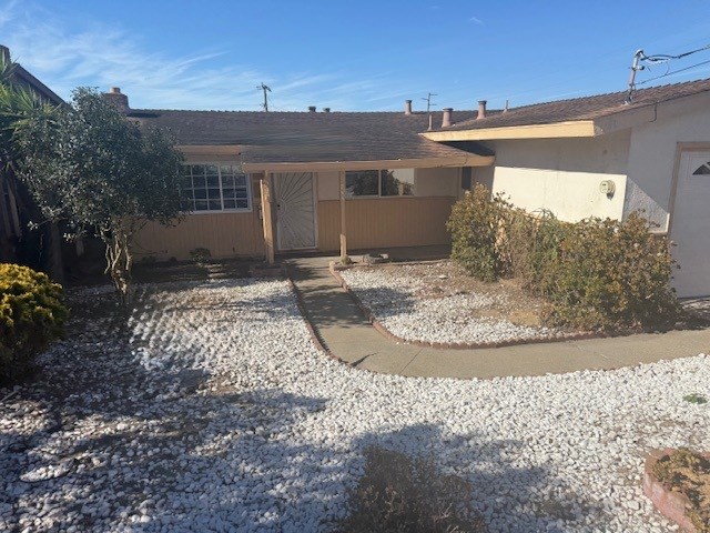 A house with a gravel driveway and a small garden.