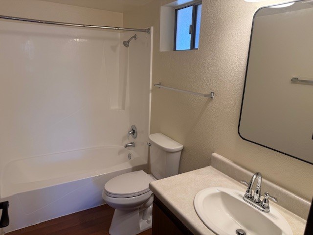 A white toilet sits next to a bathtub in a bathroom.