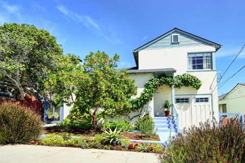 a white house with a white fence and a garden