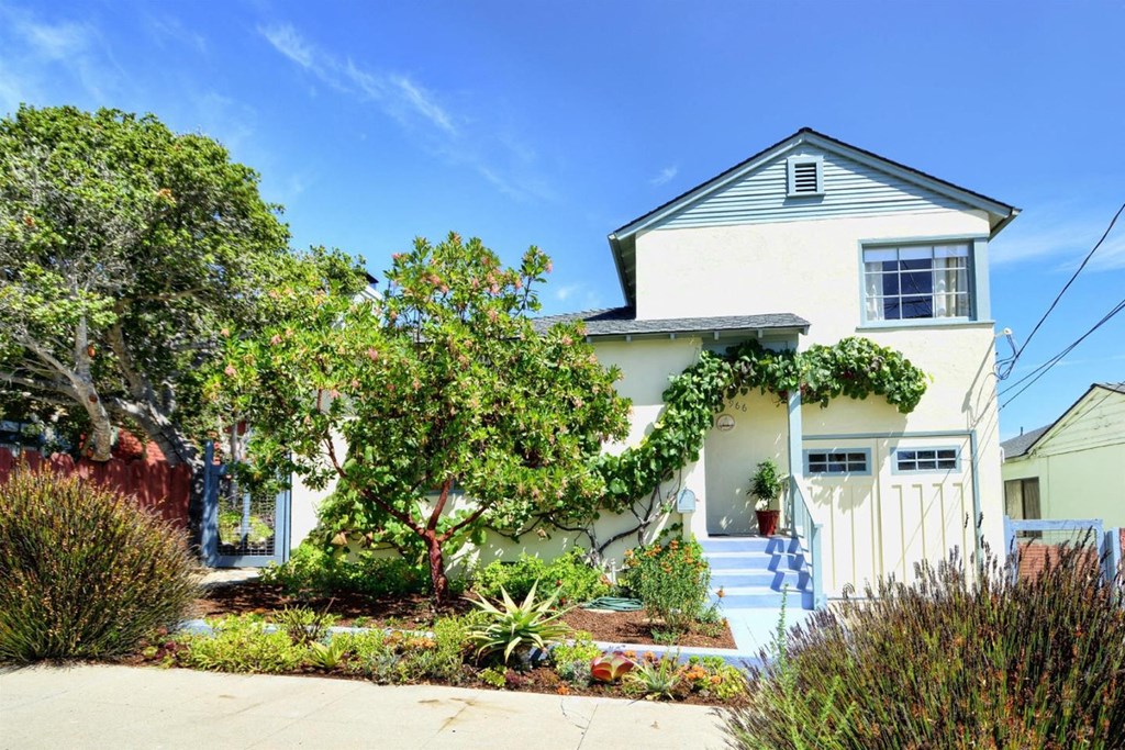 a white house with a white fence and a garden