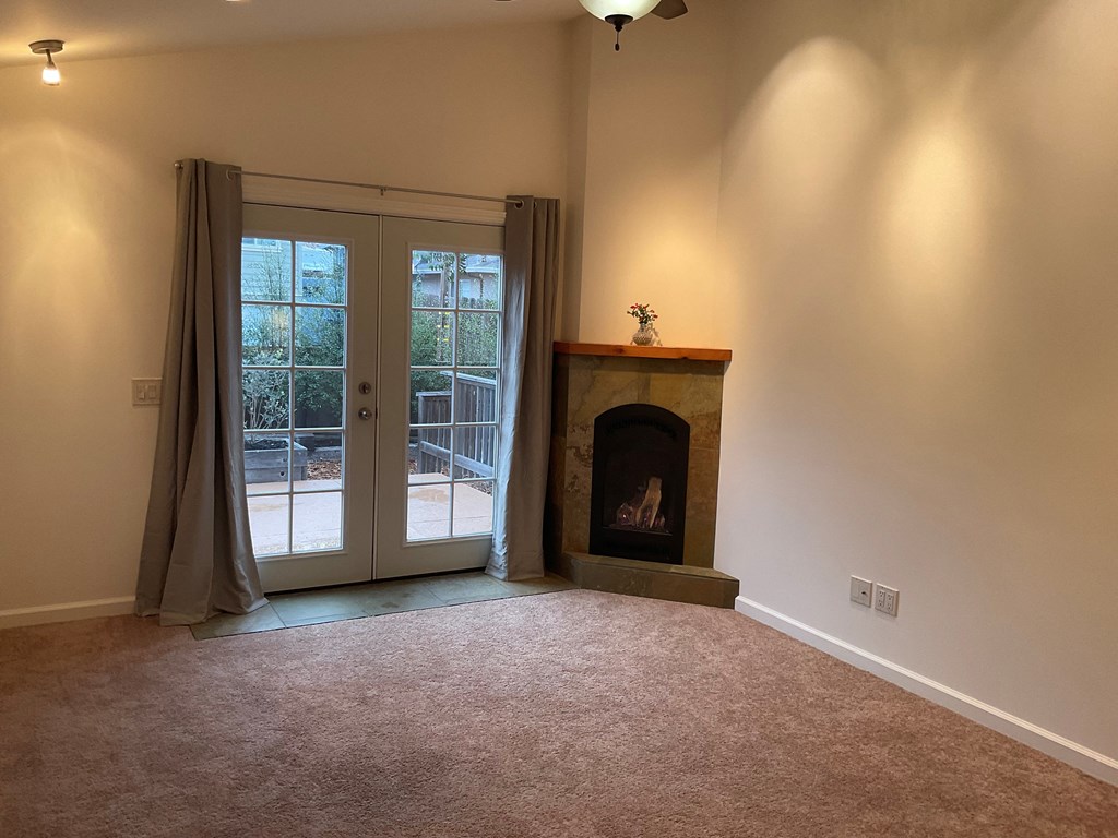 a living room with a fireplace and a door to a patio