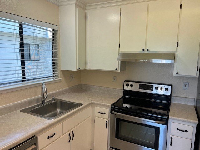 a kitchen with a stove and sink and white cabinets