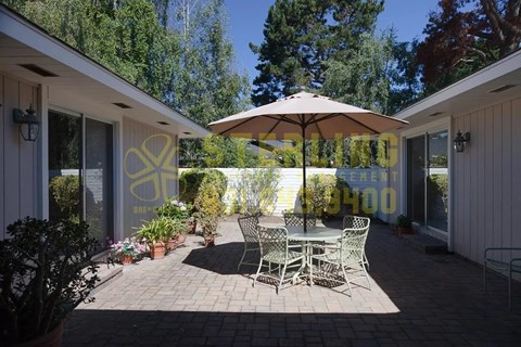 A patio with a table and chairs and an umbrella.