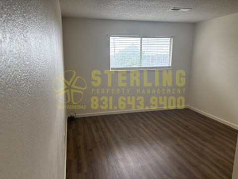 A Sterling Property Management logo is on a wall in an empty room.
