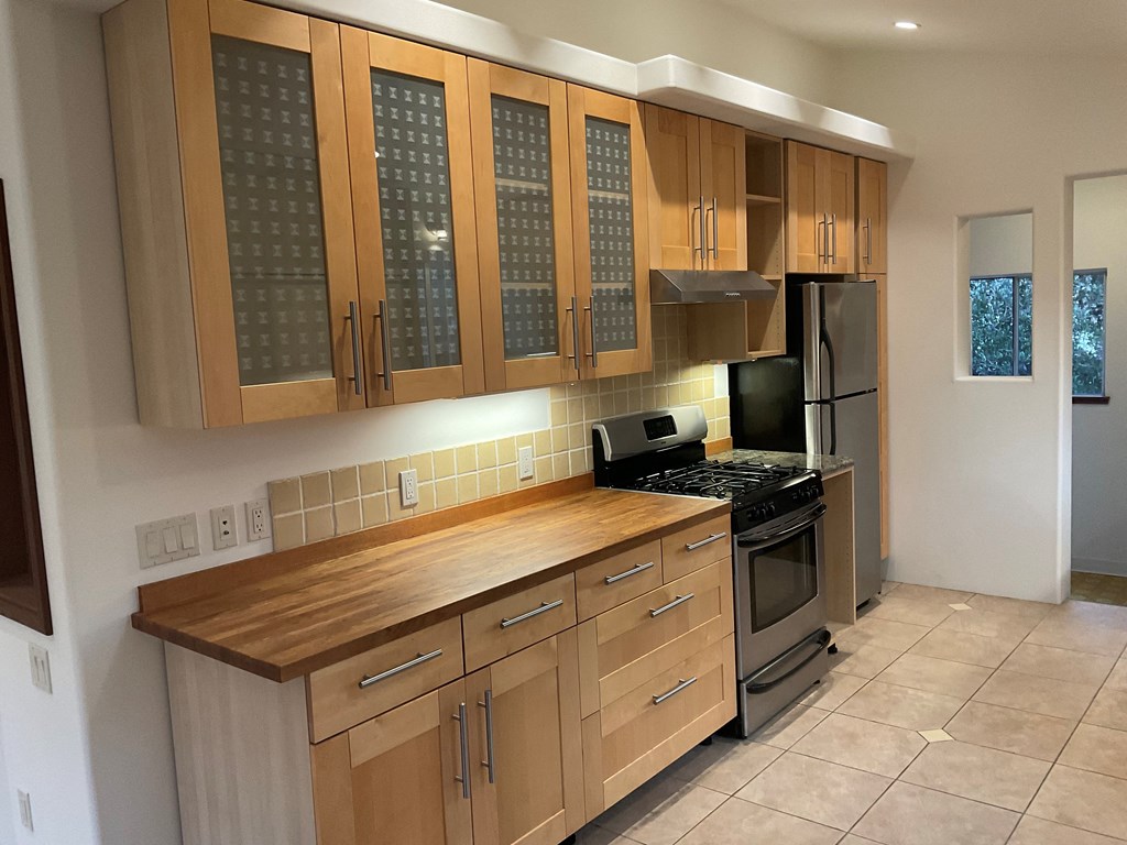 a kitchen with wooden cabinets and stainless steel appliances